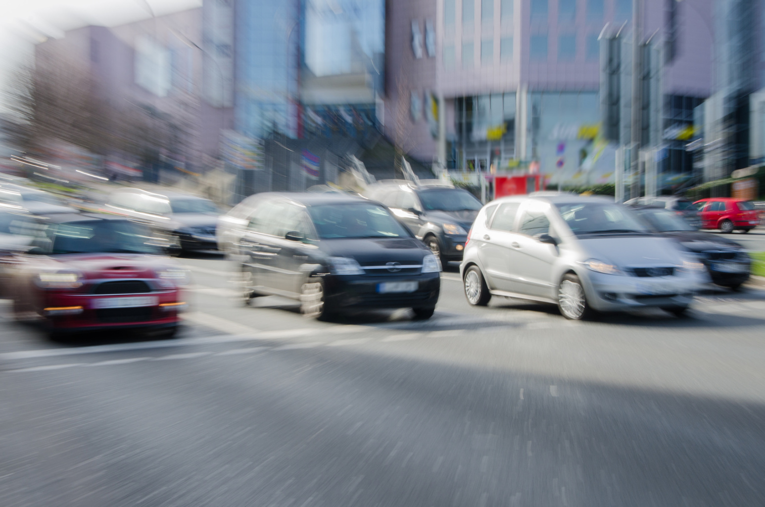 Mehrere Fahrzeuge fahren in einem verzerrten Bild von einer Ampel los; Kurtz Detektei Düsseldorf.